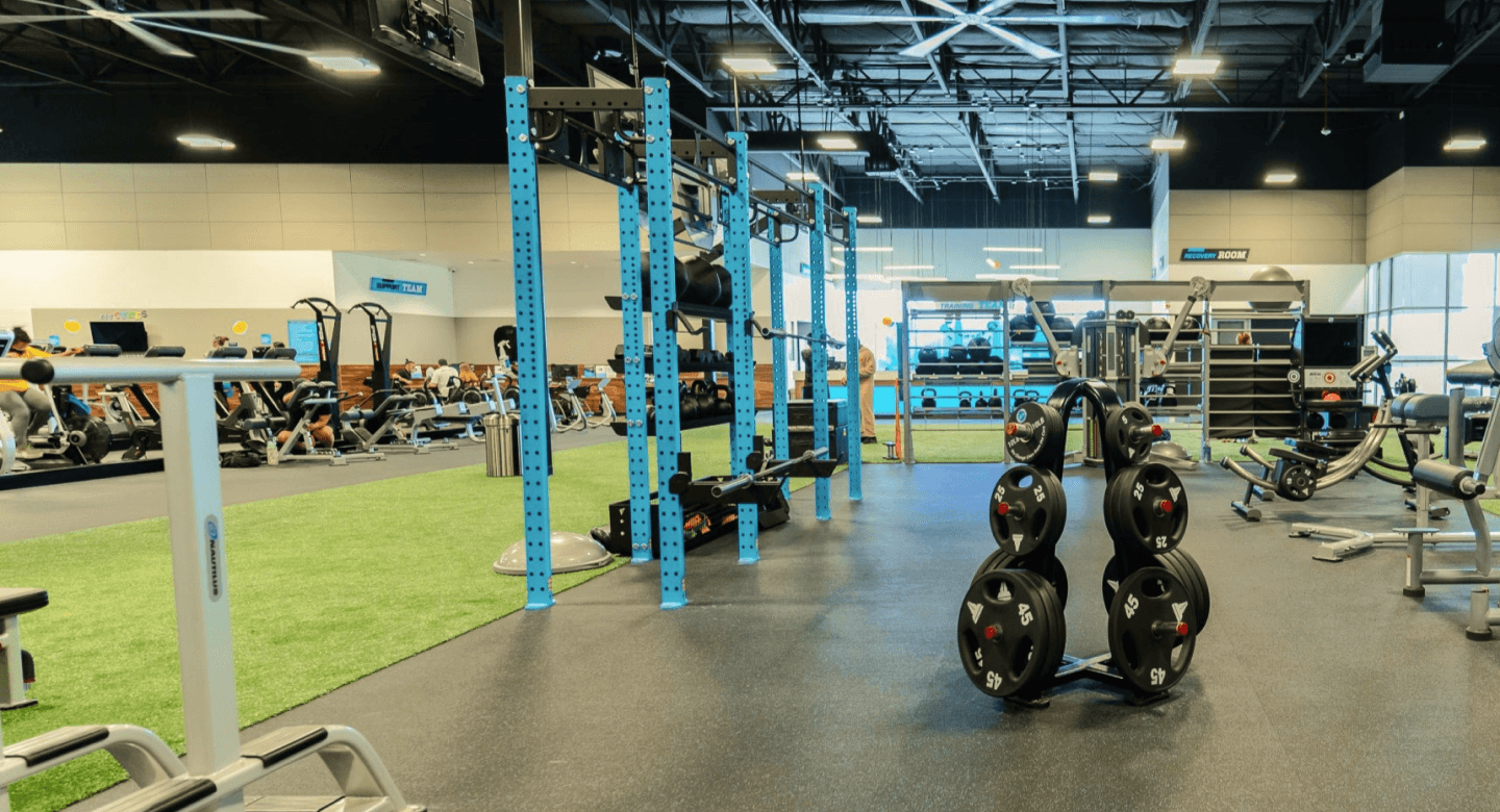 barbell weights racked in the middle of an eos branded gym