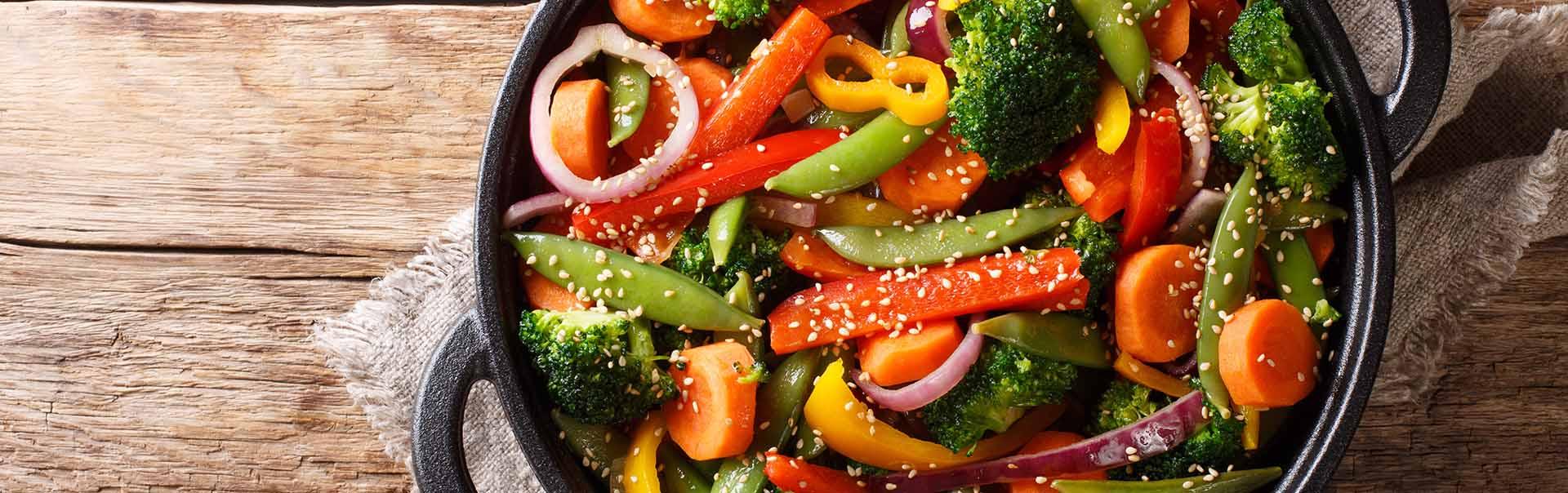 a mix of salted peppers onions green beans carrots and broccoli in a pot