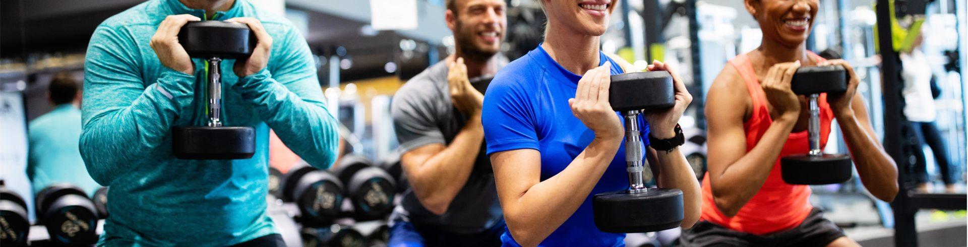 group of athletic eos gym members doing dumbbell squats
