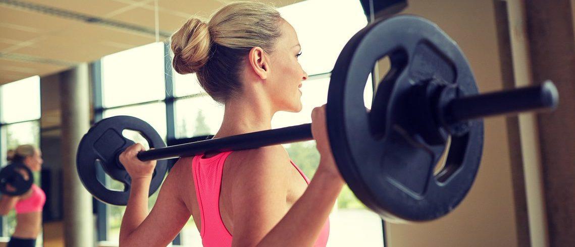 Woman lifting a barbell during a workout class